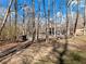 Landscaped backyard featuring mature trees, a patio, and a glimpse of the home's exterior at 6734 Pass Road, Buford, GA 30518