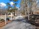 Long paved driveway leading to the property with wooded surroundings at 6734 Pass Road, Buford, GA 30518