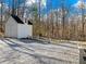 Back view of the property, displaying a shed with a gravel driveway and surrounding woods at 6734 Pass Road, Buford, GA 30518