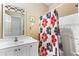 Functional bathroom with a floral shower curtain, white vanity, and large mirror at 2583 Bronco Trl, Duluth, GA 30096