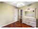 Cozy bedroom featuring hardwood floors, neutral walls, and a vintage-style dresser with mirror at 2583 Bronco Trl, Duluth, GA 30096