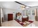 Spacious bedroom with a ceiling fan, two large windows, and an ornate, dark wood bed frame at 2583 Bronco Trl, Duluth, GA 30096