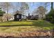 A spacious backyard with lush green grass surrounds a charming blue house with a brick chimney and wood deck at 2858 Skyland Ne Dr, Brookhaven, GA 30341