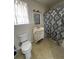 Compact bathroom featuring a vanity with sink, a toilet, and a shower with a patterned curtain at 4622 Dogwood Rd, Pine Lake, GA 30083