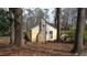 Cozy home's exterior featuring a classic stone chimney, surrounded by trees and foliage at 4622 Dogwood Rd, Pine Lake, GA 30083