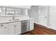 Updated kitchen showcasing stainless steel dishwasher, white cabinetry, hardwood floors, and quartz countertops for modern appeal at 795 Hammond Dr # 801, Atlanta, GA 30328