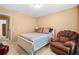 Cozy bedroom with neutral walls, soft lighting, comfortable chair, and white framed bed with striped bedding at 3402 Blaisdell Rd, Buford, GA 30519