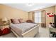 Well-lit bedroom featuring neutral walls, white-framed bed, and window with decorative curtains at 3402 Blaisdell Rd, Buford, GA 30519