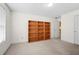 Bonus room or study with neutral walls, carpet, and built-in wood shelves, creating a functional space at 3402 Blaisdell Rd, Buford, GA 30519