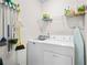Bright laundry room equipped with washing machine, dryer, and storage shelves at 3402 Blaisdell Rd, Buford, GA 30519