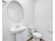 A half bath features a pedestal sink, a toilet, and wood-look flooring at 362 Rock View Ln, Covington, GA 30016