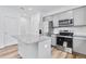 Kitchen featuring stainless steel appliances, gray cabinets, granite countertop island, and wood-look flooring at 362 Rock View Ln, Covington, GA 30016
