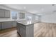 This spacious kitchen offers an island with gray cabinets and granite countertops, and wood-look flooring at 362 Rock View Ln, Covington, GA 30016