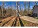 Outdoor living space showing backyard with trees, small storage shed, and gravel parking area at 387 Pine Trail, Canton, GA 30115