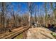 Outdoor living space showing backyard with trees, small storage shed, and gravel parking area at 387 Pine Trail, Canton, GA 30115