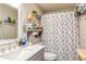 Bathroom with a toilet, sink with gray cabinets, large mirror, and patterned shower curtain at 387 Pine Trail, Canton, GA 30115