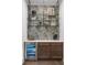 An elegant bar area with custom wallpaper, a wine cooler, and shelves styled with decor at 315 Chiswick Cir # 38, Alpharetta, GA 30009