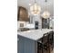 Bright kitchen featuring a large island with seating, white cabinets, a copper range hood, and modern pendant lighting at 315 Chiswick Cir # 38, Alpharetta, GA 30009