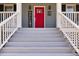 Inviting front entrance with bright red door, decorative welcome sign and fresh white stairs at 3564 Suwanee Creek Rd, Suwanee, GA 30024