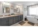 This bathroom features a soaking tub, double vanity with granite countertop and tile floors at 208 Camdale Ct, Mcdonough, GA 30252