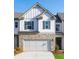 Charming townhome featuring a stone veneer, white siding, gray shutters and a two car garage at 2429 Bayberry St, Acworth, GA 30101