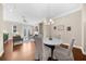 Bright dining area with hardwood floors, chandelier, and access to the living room at 4478 Dunblane Ave, Sugar Hill, GA 30518