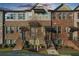 Charming townhome featuring a brick facade, individual entrances, and manicured landscaping at 4478 Dunblane Ave, Sugar Hill, GA 30518