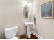 Stylish half-bathroom featuring pedestal sink, oval mirror, and decorative artwork at 4478 Dunblane Ave, Sugar Hill, GA 30518