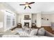 Bright living room features a fireplace, hardwood floors, and elegant French doors at 4478 Dunblane Ave, Sugar Hill, GA 30518