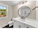 This bathroom features a white vanity with black hardware, and a round mirror at 703 Sierra Ct, Canton, GA 30114