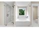 Elegant bathroom featuring a glass shower and a luxurious soaking tub with marble tile surround at 703 Sierra Ct, Canton, GA 30114