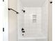 A tiled bathtub and shower feature a black shower head and built-in niches at 703 Sierra Ct, Canton, GA 30114