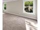 Sunlit bedroom featuring neutral carpet, two windows, and neutral walls at 703 Sierra Ct, Canton, GA 30114