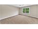 An empty bedroom features a large window and neutral carpeting at 703 Sierra Ct, Canton, GA 30114