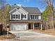 Charming two-story home with a brick facade, attached garage, and well-manicured lawn at 703 Sierra Ct, Canton, GA 30114
