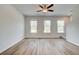 Bright living room with wood-look flooring, three windows, and a ceiling fan at 3154 Washburn Sw St, Atlanta, GA 30354