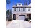 Charming townhome featuring a stone-accented facade, gray siding, and a convenient two-car garage at 2256 Triple Crown Ln, Lithonia, GA 30058