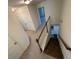 Neutral-toned hallway featuring a staircase with wooden handrail, white doors, and access to other rooms at 2256 Triple Crown Ln, Lithonia, GA 30058