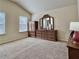 Neutral carpeted bedroom featuring a large dresser and windows with blinds to let in plenty of light at 2359 Brynfield Cv, Suwanee, GA 30024