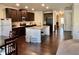 Open kitchen with a granite island, dark wood cabinetry, and stainless steel appliances at 2359 Brynfield Cv, Suwanee, GA 30024