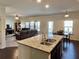 Open-concept living room with hardwood floors, granite countertops, and stainless steel appliances at 2359 Brynfield Cv, Suwanee, GA 30024