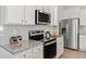 Bright kitchen with stainless steel appliances, white cabinets, and granite countertops at 7015 Old Bridge Ln, Conyers, GA 30013