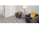 Cozy sitting area with two gray armchairs, yellow pillows, and a modern floor lamp at 7015 Old Bridge Ln, Conyers, GA 30013