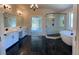 Large bathroom with marble tile, double sink vanity, glass shower, and a soaking tub at 4015 Sierra Vista Cir, Cumming, GA 30028