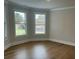 Empty bedroom with hardwood floors and large windows overlooking the neighborhood at 4015 Sierra Vista Cir, Cumming, GA 30028