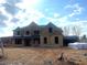 New construction home with unfinished yard, featuring a 2-car garage and modern architectural details at 4015 Sierra Vista Cir, Cumming, GA 30028