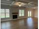 Spacious living room featuring coffered ceiling, hardwood floors, a fireplace, and natural light at 4015 Sierra Vista Cir, Cumming, GA 30028