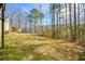 Large backyard with mature trees and partial grass cover at 581 Victorian Cir, Dallas, GA 30157