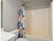 Bathroom with a tiled bathtub and a colorful shower curtain with floral pattern at 581 Victorian Cir, Dallas, GA 30157