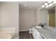 Granite countertop bathroom featuring dual sinks and a separate tub at 581 Victorian Cir, Dallas, GA 30157